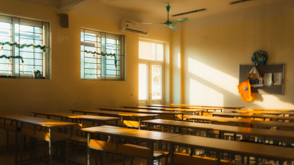 Sunlit classroom with wooden desks and warm afternoon light