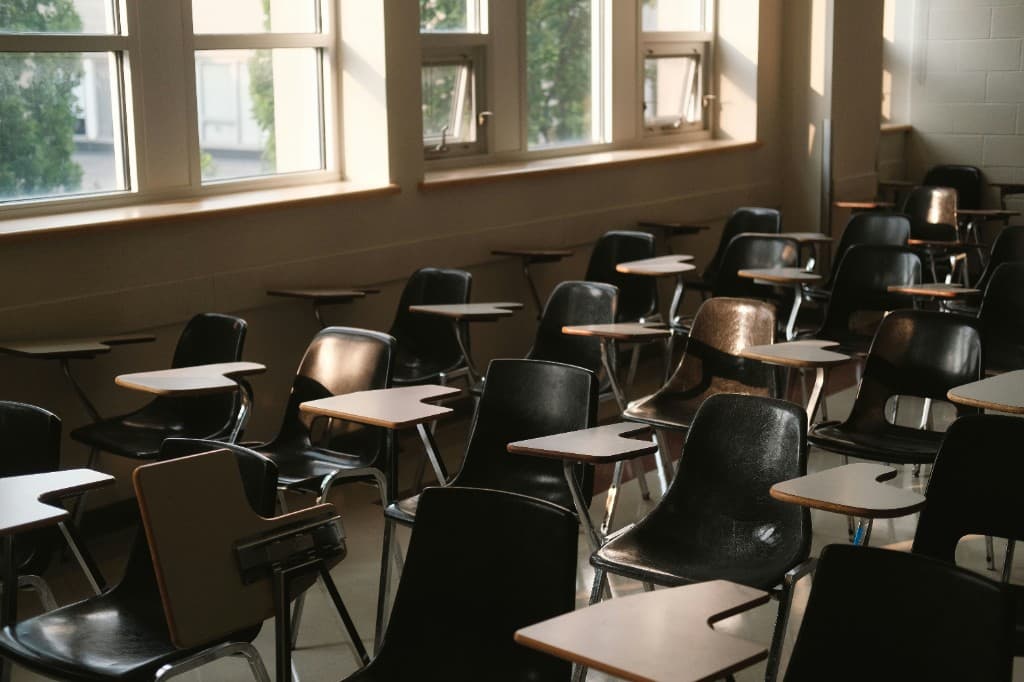 Empty classroom with rows of chairs and desks in natural daylight
